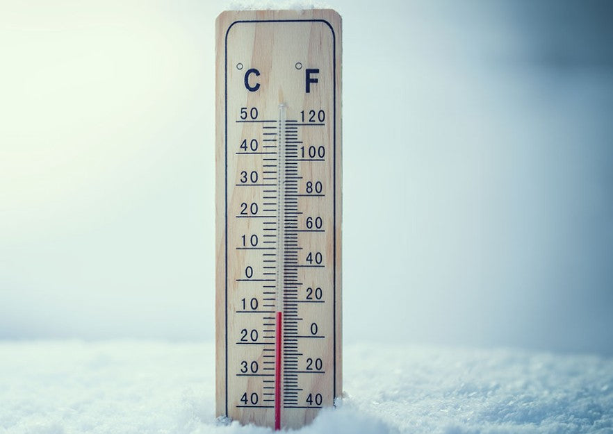 image of a wooden thermometer stuck in snow with low temperature displayed