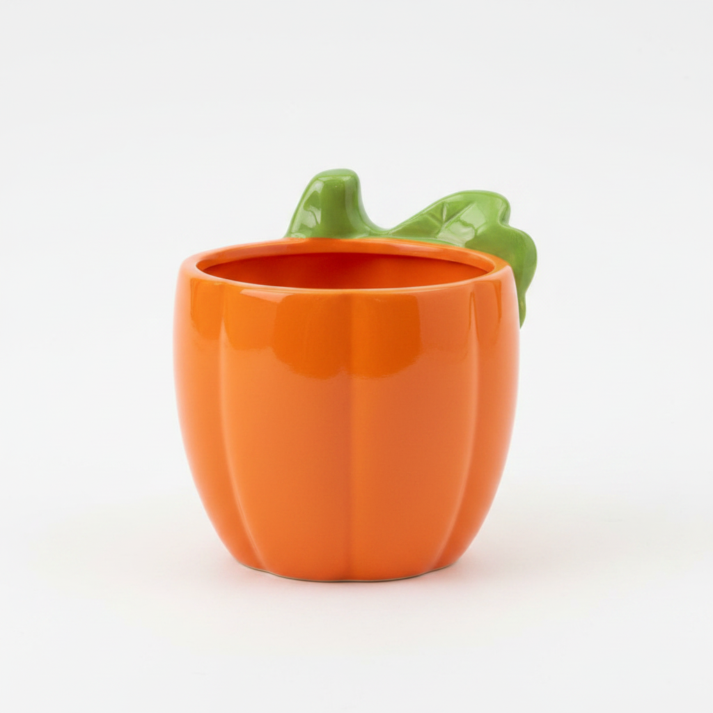 Back view of a ceramic pumpkin plant pot showing a smooth solid plain orange glossy surface with green leaf stem on top and no face