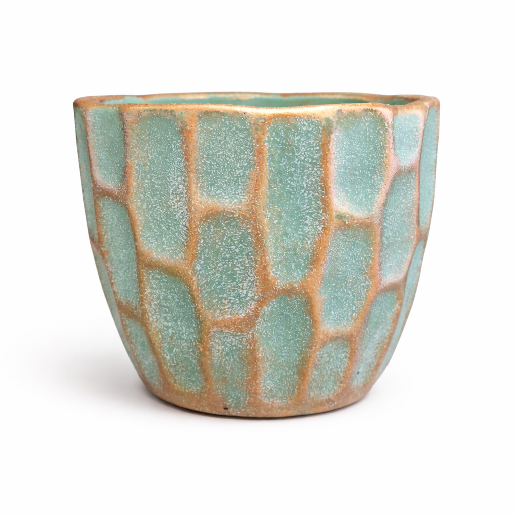 Ceramic pot with textured green and gold surface on a white background